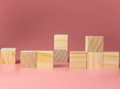 Empty wooden cube on a pink background. For new ideas to be put into the picture.Rear focus.