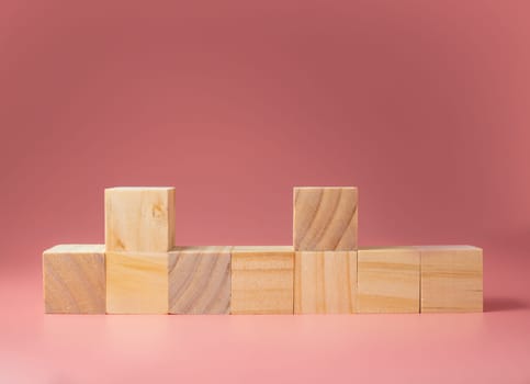 A wooden cube on a pink background.For new ideas to be put into the picture.