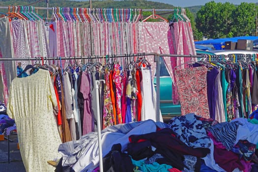 Blouse dress and pants hanging at clothes rails flea market