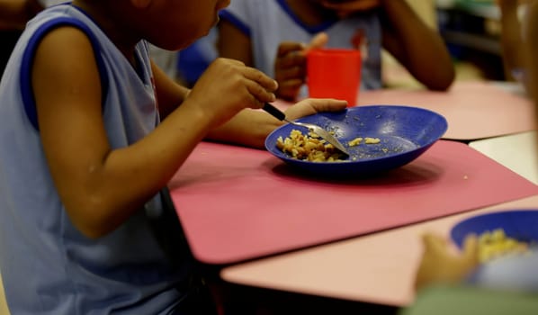 salvador, bahia / brazil - march 22, 2019: child is seen eating school lunch in criche in the city of Salvador.