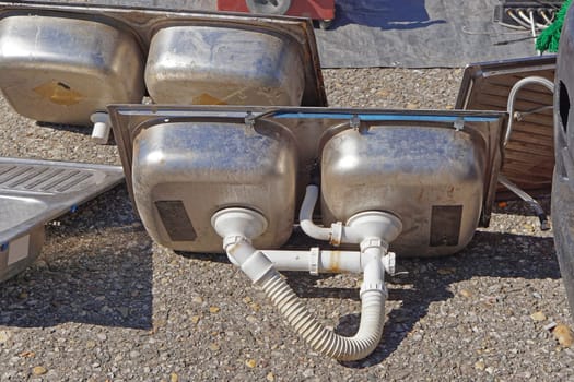 Old stainless steel metal double sink with plumbing