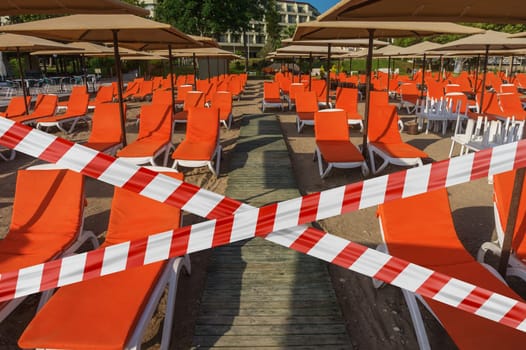 Protective tape on background beach with sun loungers and parasols in Kemer