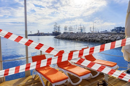 Protective tape on background sun loungers amid sailboats in the town of Kemer.