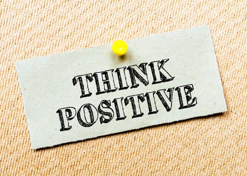 Recycled paper note pinned on cork board.Think positive Message. Concept Image