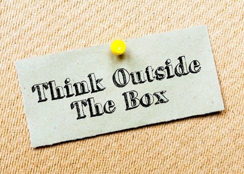 Recycled paper note pinned on cork board.Think Outside the Box Message. Concept Image