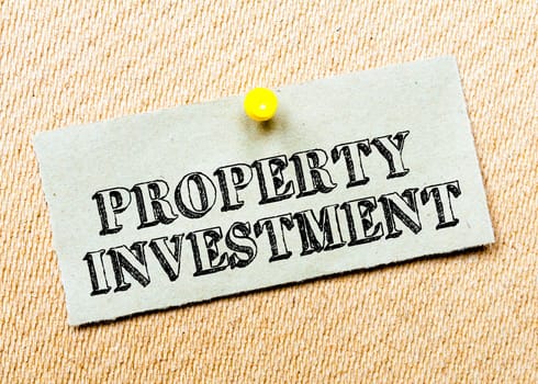 Recycled paper note pinned on cork board. Property Investment Message. Concept Image