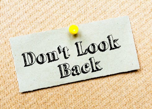 Recycled paper note pinned on cork board. Don't Look Back message. Concept Image