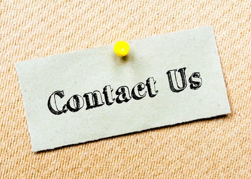 Recycled paper note pinned on cork board.Contact Us Message. Concept Image