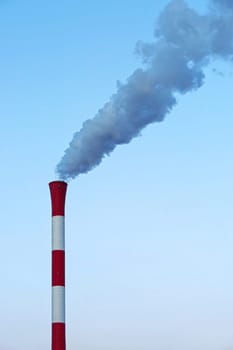 Red and white chimney with smoke