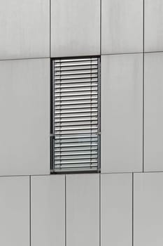 Rectangular window with metal blinds at modern building