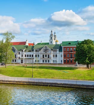 Sunny cityscape with church towers and old town architecture by the River Svisloch in Minsk, Belarus