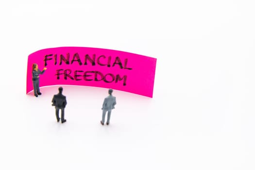 Presentation meeting with miniature figurines posed as business people standing in front of post-it note with Termination of Employment handwritten message in background, copy space on the right