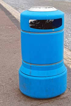 Blue plastic trash can at street