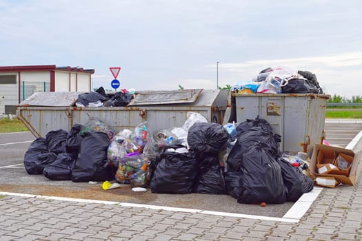 Overflow of garbage litter and empty trash can