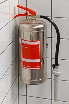 Silver fire extinguisher in building corner