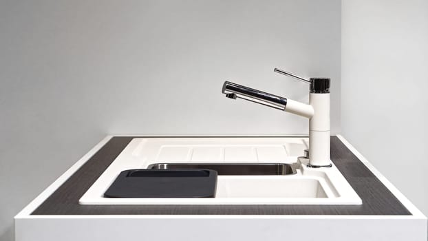 White kitchen sink with modern faucet