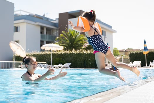 Child Jumping In Swimming Pool In Summer