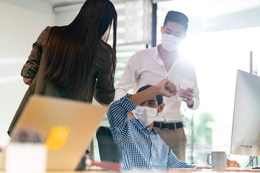 Businessperson do alternative greeting in new normal office lifestyle. They wear protective face mask and use elbow touch instead of hand shake to reduce infection of coronavirus COVID-19.