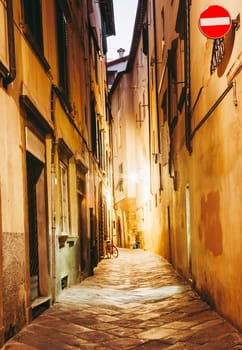 Narrow street in the historic part of Lucca, Italy at night