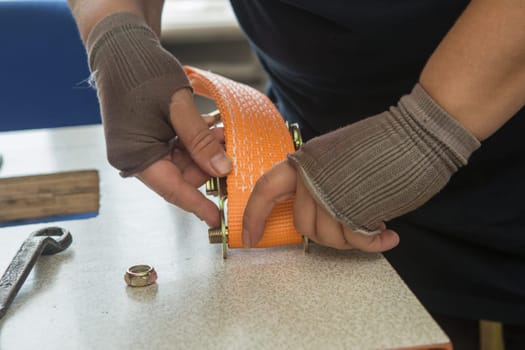 Industrial sewing machine sews a webbing sling. Manufacture of textile slings and tie straps