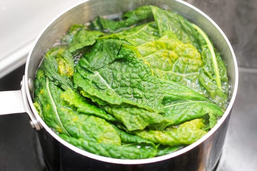Cooking leafy green swiss chard in pot