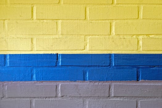 Yellow blue and grey wall made from bricks background
