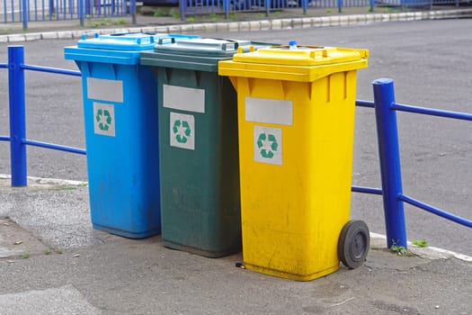 Three plastic recycling bins for sorting waste