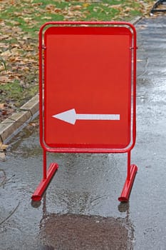 Red direction board at sidewalk