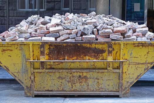 Over filled skip container with brick debris