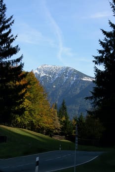 Alpine summits covered with snow, blue sky in the background .