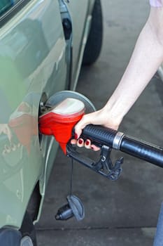 Woman filli up car with gas at petrol station