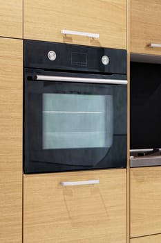 Black oven in modern kitchen cabinets