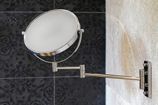 Double sided round makeup beauty mirror at wall in bathroom