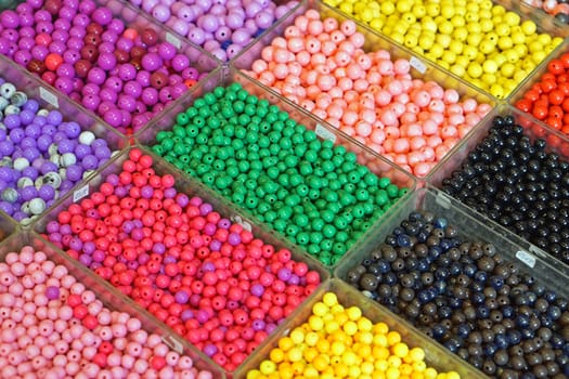 Various colorful plastic beads in trays