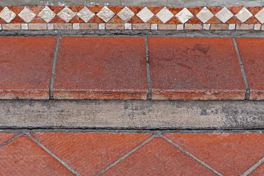 Red stone step with decorative tiles