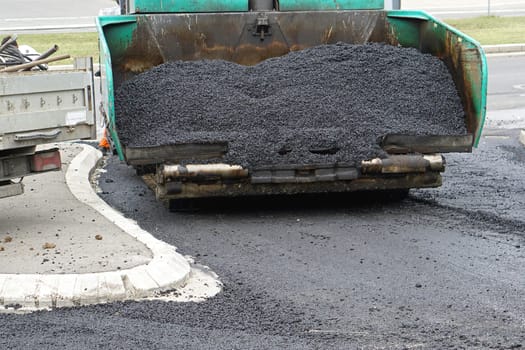 Fresh new pile of asphalt in surfacing road machine