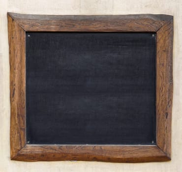 Blackboard with wooden frame at wall