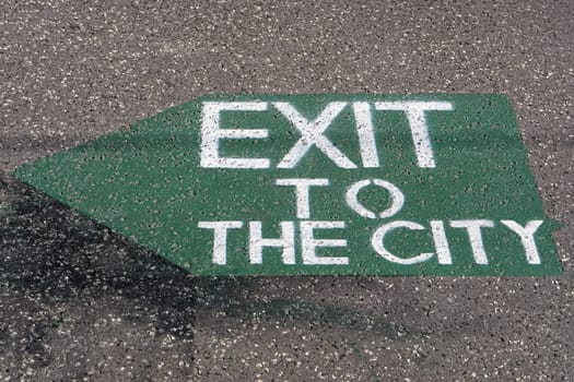 Exit to the city sign with arrow at pavement