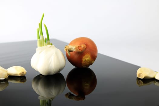 Garlic on a black plate wanders across the picture