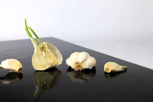 Garlic on a black plate wanders across the picture