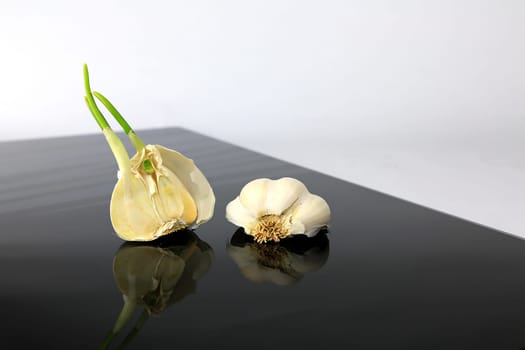 Garlic on a black plate wanders across the picture