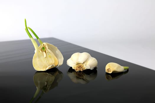 Garlic on a black plate wanders across the picture