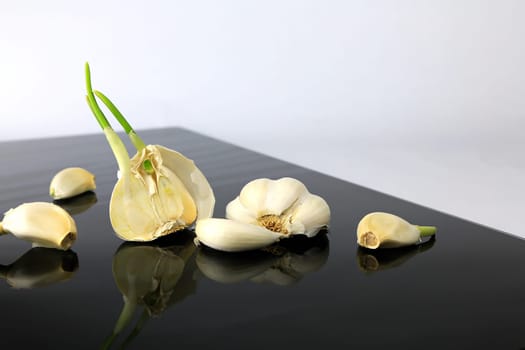 Garlic on a black plate wanders across the picture