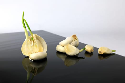 Garlic on a black plate wanders across the picture