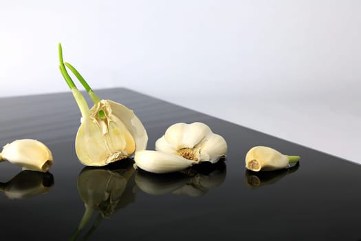 Garlic on a black plate wanders across the picture