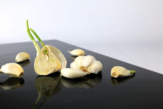 Garlic on a black plate wanders across the picture