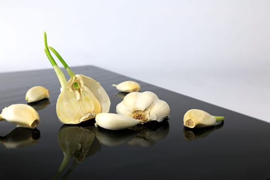 Garlic on a black plate wanders across the picture