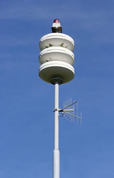 A street lamp, blue sky in the background.
