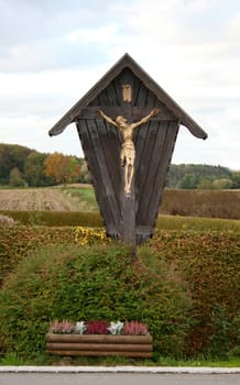 A wayside cross wooden with fields in the background