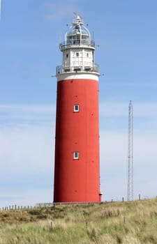 red lighthouse with blue sky in the background.